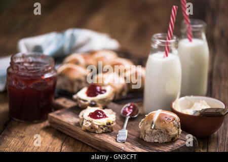 cremige Tee, heiße Kreuz Brötchen mit Marmelade und Clotted cream Stockfoto