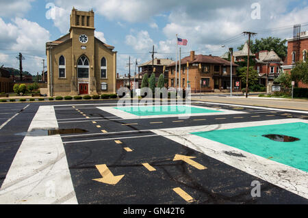 Pfeile zeigen in entgegengesetzte Richtungen auf einem Parkplatz neben einer historischen Kirche in Zanesville, Ohio. Stockfoto