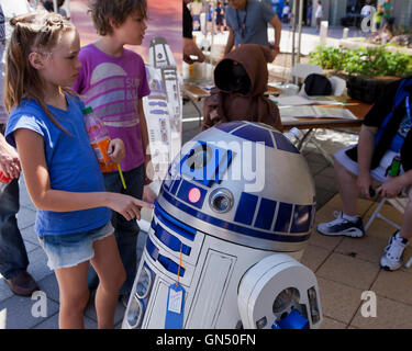 Junge Mädchen die Interaktion mit R2-D2-Figur bei Maker Faire-Washington, DC, USA Stockfoto