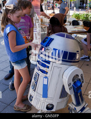 Junge Mädchen die Interaktion mit R2-D2-Figur bei Maker Faire-Washington, DC, USA Stockfoto