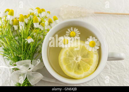 Kamillentee mit Zitronenscheiben und Blumen Stockfoto