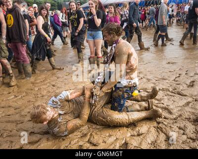 Festivalbesucher Ringen in den Schlamm beim Leeds Festival im Braham Park, West Yorkshire. Stockfoto