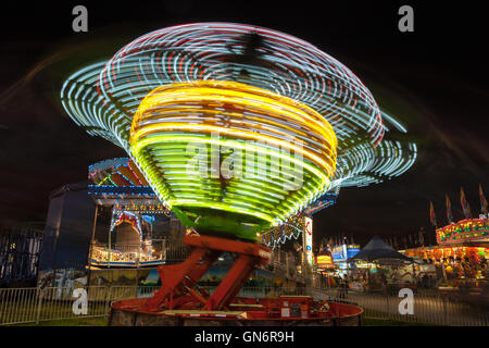 Bunt beleuchtete Fahrgeschäfte drehen gegen den Nachthimmel während der New Jersey State Fair in Augusta im US-Bundesstaat New Jersey. Stockfoto