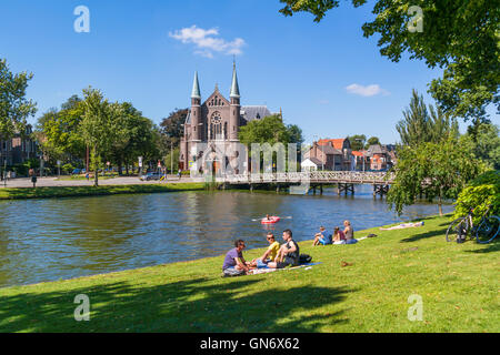 Menschen genießen und entspannen auf Rasen Singelgracht und St. Joseph Kirche in Alkmaar, Niederlande Stockfoto