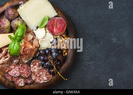 Italienischer Wein Snacks Vielfalt über dunkle Sperrholz Hintergrund, Textfreiraum Stockfoto