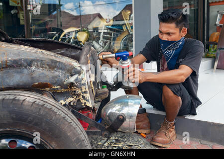 BALI, Indonesien - März 20: Junge Balinese Mann reinigt Körper eines alten VW-Käfer während wiederherstellen benutzerdefinierte Oldtimer Stockfoto