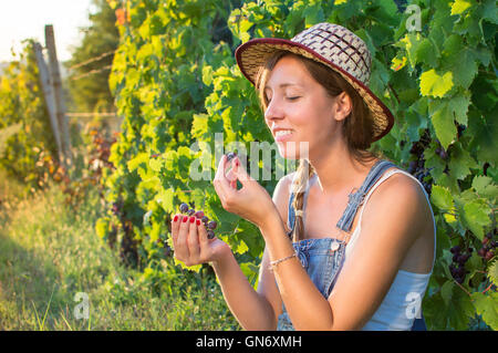 Glückliche Frau genießen frische Trauben im Weinberg Stockfoto