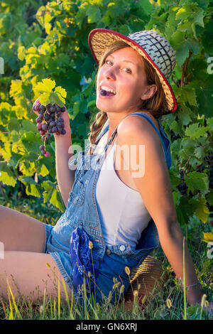 Glückliche Frau genießen frische Trauben im Weinberg Stockfoto