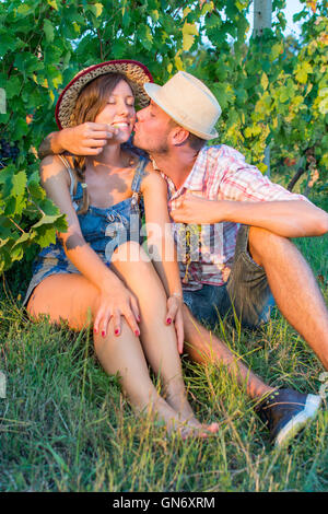 Glückliches Paar teilen frische Trauben im Weinberg Stockfoto