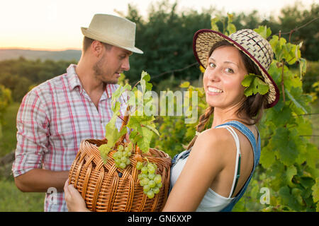 Paar in der Weinlese am Weinberg mit einem Weidenkorb Stockfoto