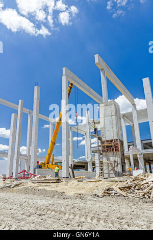 Mobiler Kran arbeitet daran, große Montagehalle. Platzieren den Dachstuhl auf den Aufbau von Skelett. Stockfoto