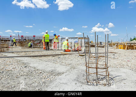 Arbeitnehmer sind Bewehrung um einen neu errichteten Fundament Rahmen binden. Verbindliche Betonrahmen Stockfoto