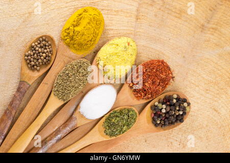 Gewürze in Holzlöffel auf einem Holztisch Stockfoto