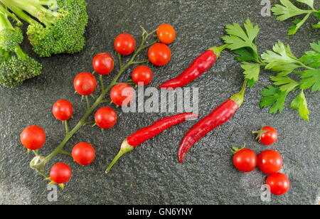 Rohe Tomaten und Paprika auf Stein Hintergrund Stockfoto