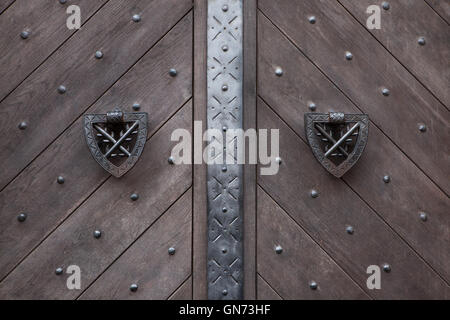 Tuerklopfer auf das hölzerne Tor mit Nieten in Burg Kokorin in Mittelböhmen, Tschechien fixiert. Stockfoto