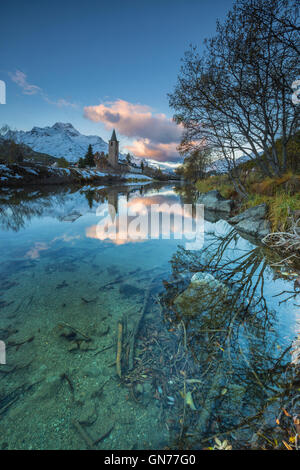 Dawn beleuchtet die schneebedeckten Gipfel und der Glockenturm spiegelt sich im See Sils Engadin Kanton Graubünden Schweiz Europas Stockfoto