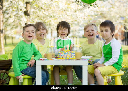 Glücklich, süße Kinder im Vorschulalter, Freunde und Verwandte, feiert fünften Geburtstag des netten jungen, outdoor im blühenden Apfel Baum ga Stockfoto