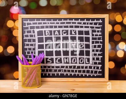 humorvolle Konzept der Schule hassen, wie Gefängnis mit Text zurück zur Schule in Tafel, Stifthalter auf Holztisch über Blu geschrieben steht Stockfoto
