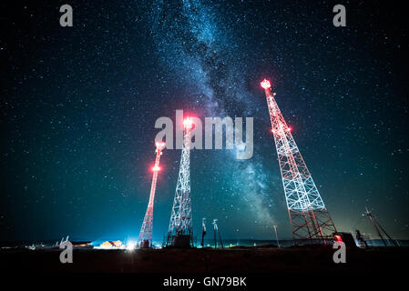 Stromleitungen gegen Nacht Himmel und Milchstraße Galaxie Stockfoto