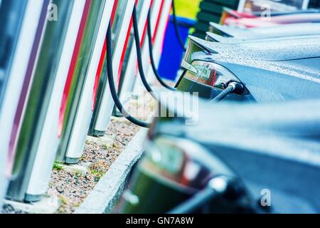 Elektrofahrzeuge mit öffentlichen im Freien elektrische Ladegeräten aufladen. Moderne Elektroautos im Einsatz. Zukunft des Verkehrs. Stockfoto