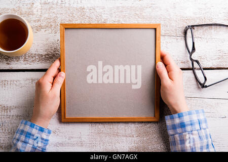 Nicht erkennbare Frau mit leeren Grafikrahmen, Studio gedreht. Stockfoto