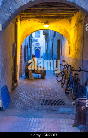 Essaouira, Marokko.  Lieferung Warenkorb in einer Seitenstraße von Medina. Stockfoto