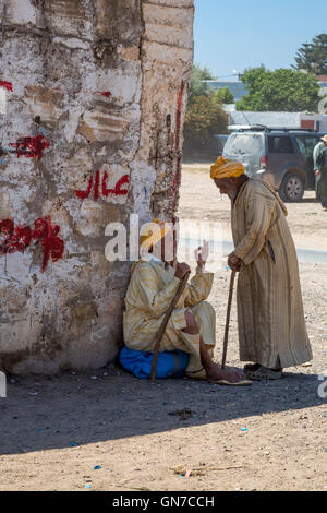 Marokko.  Zwei alte Männer reden im Schatten, hatte Draa Markt, Essaouira Provinz. Stockfoto