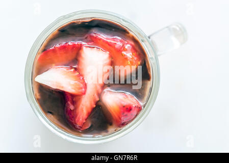 Schokoladenmousse garniert mit Erdbeeren Obst im Glas auf weißem Hintergrund Draufsicht Stockfoto