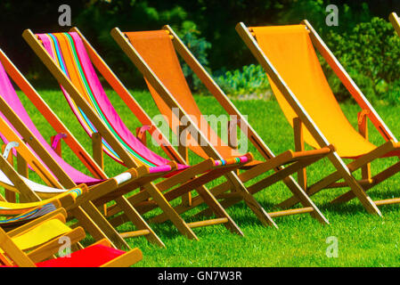 bunte Strandkörbe in Reihe auf dem Rasen Stockfoto