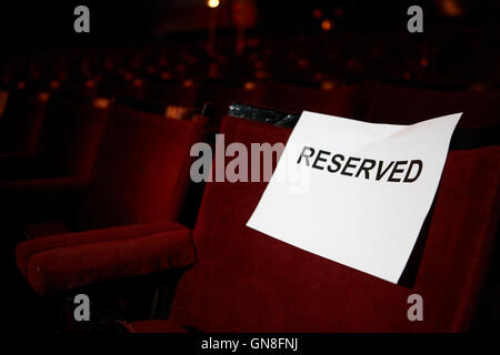reservierte Zeichen auf einem Sitzplatz in einer Sitzreihe im Parterre eines alten Stil-Theaters Stockfoto