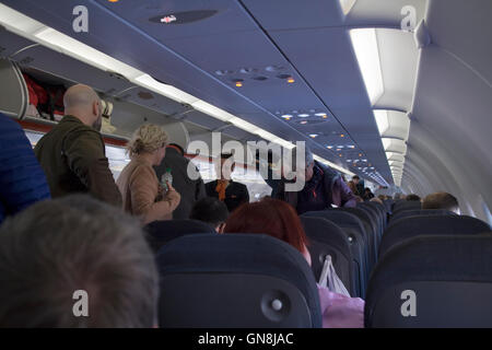 Passagiere, die zu Fuß hinunter Aisle Easyjet-Flugzeuge Stockfoto