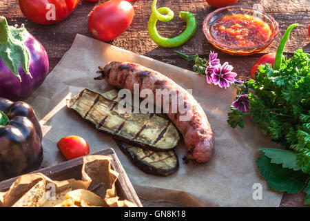 Gegrillte Würstchen und Gemüse auf hölzernen Hintergrund Stockfoto