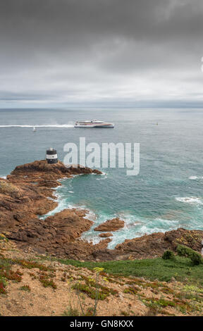 Condor-Corporate Katamaran Fähre HSC Condor Befreiung fährt durch den Leuchtturm Noirmont Zeitpunkt, Jersey. Stockfoto