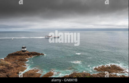 Condor-Corporate Katamaran Fähre HSC Condor Befreiung fährt durch den Leuchtturm Noirmont Zeitpunkt, Jersey. Stockfoto