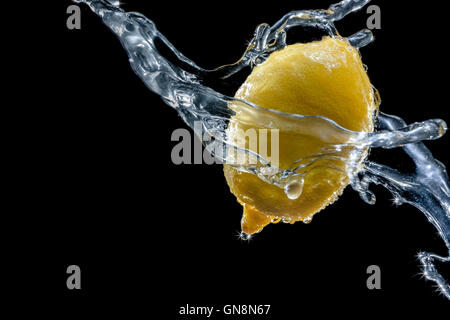 Zitrone in einem Spray gegen einen schwarzen Hintergrund. Close-up. Eine Reihe von Obst und Gemüse in Bewegung. Stockfoto