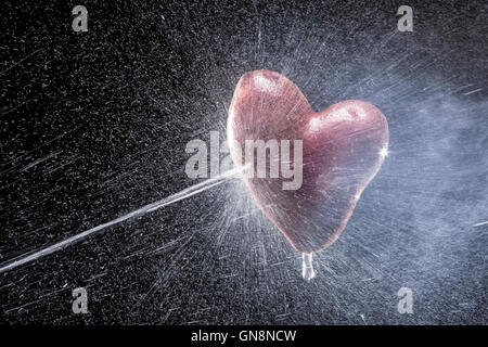 Kartoffeln in Form von Herzen. Auf einem schwarzen Hintergrund. Eine Reihe von Obst und Gemüse in Bewegung. Zum Valentinstag Stockfoto