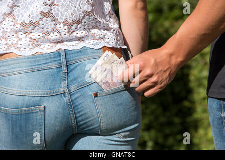 Dieb nehmen Geld - ist ein Taschendieb nehmen Geld von einem Mädchen Gesäßtasche Stockfoto