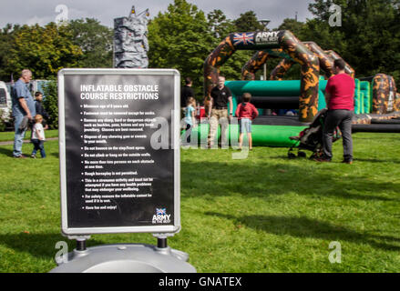 Kinder spielen in Ormskirk, Lancashire, Großbritannien British Army Angriff Hindernisparcours Hüpfburg Hüpfburgen im Central Park. VEREINIGTES KÖNIGREICH Stockfoto