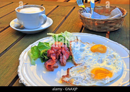 Englisches Frühstück auf dem Holztisch: Sonnenseite Eier mit Speck und Gemüse Stockfoto