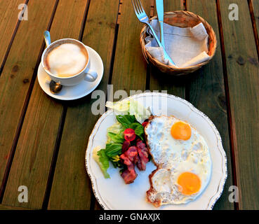 Sonnenseite Eier mit Speck und Gemüse und Kaffeetasse auf dem Tisch Stockfoto