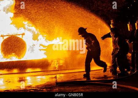 Feuerwehrmann läuft auf Feuer Stockfoto