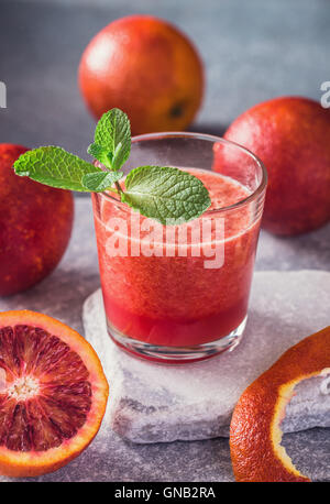 Glas frisch auf Stein Hintergrund Blutorange Stockfoto