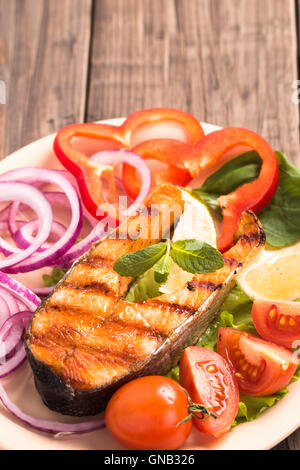 Gegrilltes Lachssteak mit Tomaten vertikale Stockfoto