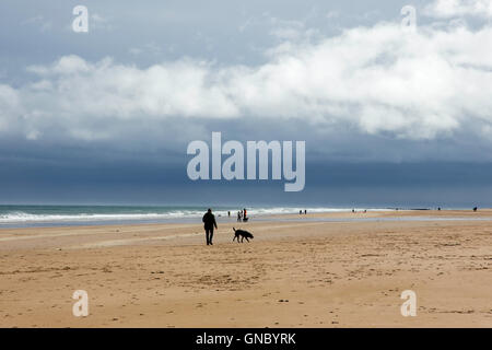Spaziergang mit dem Hund auf Bamburgh Castle, Northumberland Küste, England, UK Stockfoto