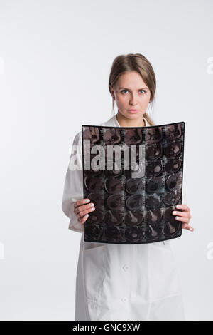 Porträt von nachdenklich Ärztin in der weißen uniform Blick auf das Röntgenbild. Stockfoto