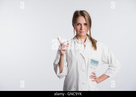 Junger Arzt Frau Krankenschwester präsentieren und zeigen textfreiraum für Produkt oder Text. Kaukasische weiblichen Arzt isoliert auf weißem Hintergrund. Stockfoto