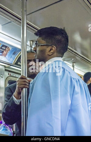 feiner junger Mann indischer Abstammung in Columbia University Graduierung Kleid auf uptown 6 trainieren immer intensiver Beratung von seinem Vater Stockfoto