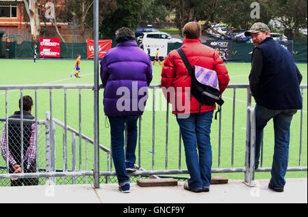 Übergeordneten Zuschauern ein junior fangen Sie Hockey-Spiel in Melbourne, Australien. Stockfoto