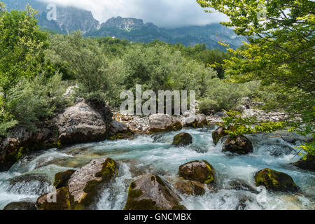 Der Thethit Fluss in das Dorf von Theth mit mit dem Radohima-massiv im Hintergrund, Nordalbanien. Stockfoto