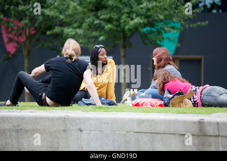 LONDON, UK - 14. August 2016: - Briten chillen bis nach der Arbeit auf dem Rasen in South Bank in London Stockfoto